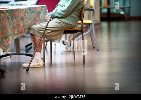 Donna anziana con la canna in una casa di riposo. Foto Stock