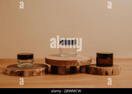 Un primo piano del contenitore del prodotto di cura della pelle su un ceppo dell'albero tagliato come sfondo bello Foto Stock