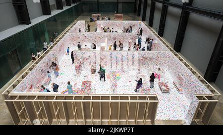 Guardando verso il basso sulla sala d'obliterazione all'interno della Tate a Londra. Creato da Yayoi Kusama, le famiglie camminano intorno ad una casa improvvisata decorandola con c Foto Stock