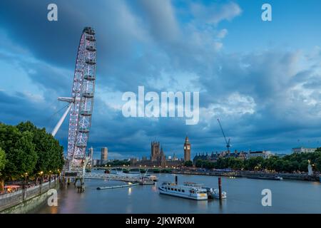 Il giorno si trasforma in notte quando la luce svanisce sul London Eye e sul Tamigi nel luglio 2022 a Londra. Foto Stock