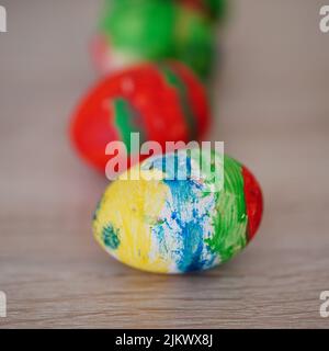 Un primo piano di un colorato dipinto di uova di pasqua su un tavolo di legno Foto Stock