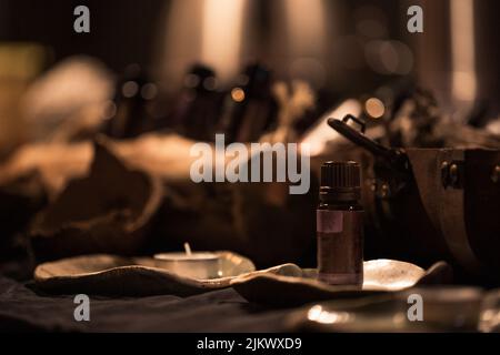 Un flacone contagocce di medicinale con fondo sfocato scuro e decorazioni Foto Stock