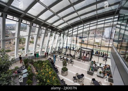 I turisti godono di vedute di Londra dallo Sky Garden sulla cima del Walkie Talkie Building nell'agosto 2022. HMS Belfast e Tower Bridge sulla Rive Foto Stock