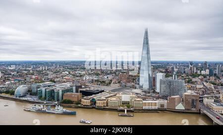 Lo Shard domina lo skyline di Londra dato che si trova accanto alla stazione ferroviaria di London Bridge. L'HMS Belfast può essere visto accanto alla Scoop e al municipio B. Foto Stock