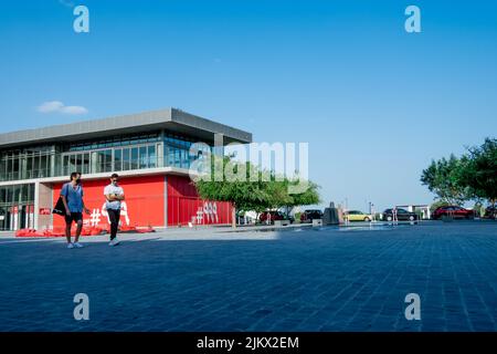 Due uomini si svegliano nella piazza del Qatar vicino al Museo della stazione dei vigili del fuoco di Doha. Foto Stock