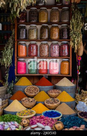 Diverse spezie di colore brillante in recipienti di vetro di fila in un negozio di spezie mercato a Marrakesh, Marocco Foto Stock