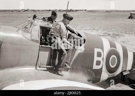 I montatori di strumenti installano una telecamera aerea (tipo F.24 (obiettivo da 14 pollici) nella posizione obliqua della porta in una North American Aviation P-51 Mustang Mark IA di No. 35 (Reconnaissance) Wing a Gatwick, Sussex, Inghilterra. Foto Stock