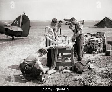 L'equipaggio e gli armatori di terra riempono le munizioni con .303 proiettili di Hawker Hurricane Mark è di No. 85 Squadron RAF a Lille-Seclin, Francia. L'aereo da caccia britannico a posto singolo ha combattuto in tutti i principali teatri della seconda guerra mondiale. Foto Stock