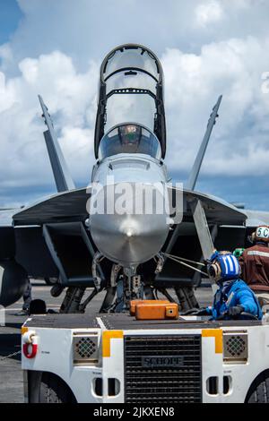 11 luglio 2022 - Philippine Sea - i marinai si preparano a prendere in taxi un EA-18G Growler attaccato al 'Shadowhawks' di Electronic Attack Squadron (VAQ) 141 sul ponte di volo dell'unica compagnia aerea statunitense USS Ronald Reagan (CVN 76). Il ruolo principale di EA-18G Growlers è quello di interrompere la capacità di comunicare tra le unità in combattimento attraverso l'uso di guerra elettronica. Ronald Reagan, il fiore all'occhiello del Carrier Strike Group 5, fornisce una forza pronta per i combattimenti che protegge e difende gli Stati Uniti, e sostiene alleanze, partnership e interessi marittimi collettivi nell'area Foto Stock