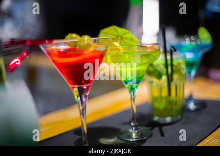 Fila di diversi bicchieri martini sul banco in un bar Foto Stock