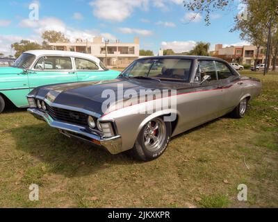 Avellaneda, Argentina - Mar 20, 2022 - vecchio popolare Chevrolet Chevy Impala quattro porte berlina fine 1960s da GM parcheggiato in campagna. Erba naturale e. Foto Stock