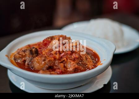 Un primo piano di zuppa di coda di Ox in una ciotola bianca su un tavolo in un ristorante cinese Foto Stock