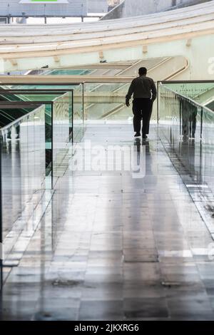 Un uomo che cammina all'interno della stazione Gare do Oriente CP Comboios de Portugal in Parque das Nacoes Foto Stock