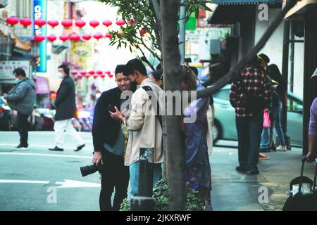 Un bellissimo scatto di due amici asiatici che guardano qualcosa insieme sul cellulare durante il giorno a Chinatown, San Francisco, California, Stati Uniti Foto Stock