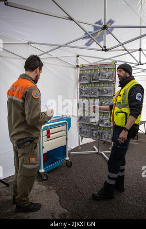 Il colpo verticale di due uomini provenienti dalla protezione civile e le infrastrutture di ambulanza lavoro in collaborazione Foto Stock