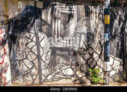 Arte di strada, murale di Canavar raffigurante due uomini dietro una recinzione a Moda, Kadiköy distretto di Istanbul, Turchia Foto Stock