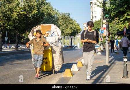 Riciclaggio informale adolescente lavoratore trascinando grande mano-tirato carrello. Raccoglitori di rifiuti riciclabili a Istanbul, Turchia Foto Stock