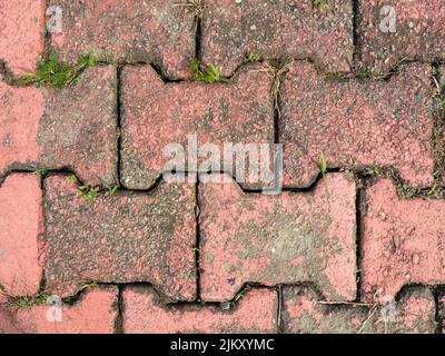 Vecchie piastrelle rosse a terra. Luogo abbandonato. Modello di pietra. Sfondo da materiali duri. Marciapiede bello Foto Stock