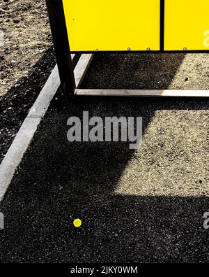 Cappuccio giallo i nl ombra dal muro giallo della costruzione urbana Foto Stock