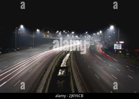 Un'esposizione lunga di un'autostrada con luci per la strada di notte Foto Stock