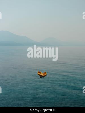 Uno scatto verticale di due navi che si muovono sul mare in una giornata nuvolosa Foto Stock