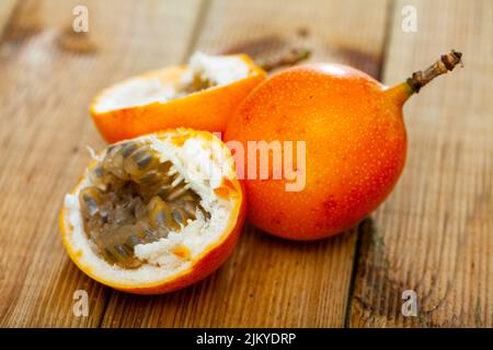 Frutta intera e mezza granadilla fresco su tavola di legno Foto Stock