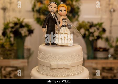 Una torta di nozze con figurine di sposa e sposo Foto Stock