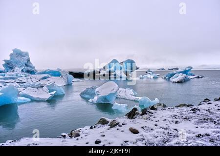 Grandi iceberg blu galleggiano sul Lago del Ghiacciaio Fjallsarlon, Islanda. Foto Stock