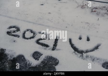 2021 e il volto sorridente disegnato nella neve Foto Stock