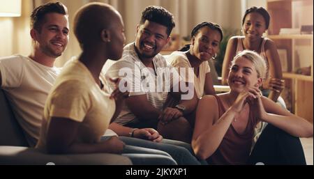 Vedere i miei amici più vicini è molto divertente: Un gruppo di amici diversi si rilassa nel salotto di casa. Foto Stock