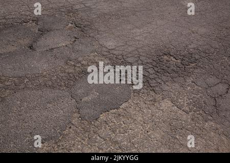Primo piano di pavimentazione in asfalto incrinato. Foto Stock