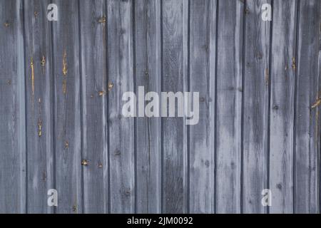 Primo piano del rivestimento della tavola in legno esposto agli agenti atmosferici sul lato di un capannone di stoccaggio. Foto Stock