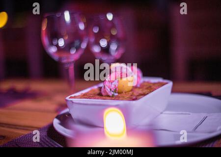 Pesce lasagne in una padella lucida sul tavolo Foto Stock