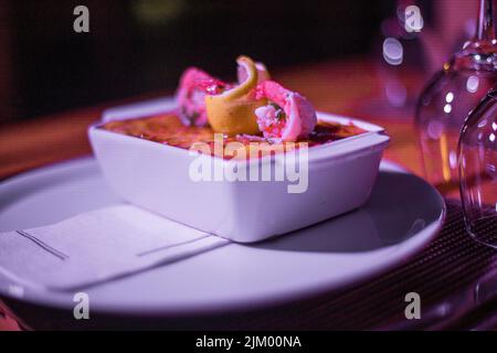 Pesce lasagne in una padella lucida sul tavolo Foto Stock