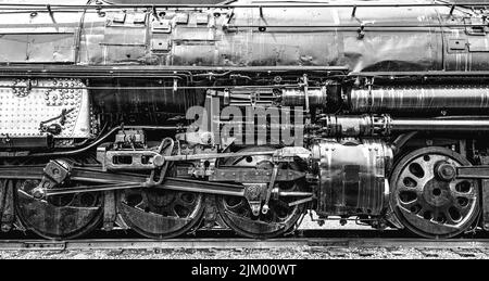 Un primo piano in scala di grigi delle ruote e delle parti meccaniche della locomotiva Union Pacific Big Boy Foto Stock