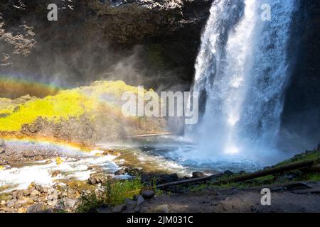 cascata profonda nella foresta con arcobaleno in fondo Foto Stock