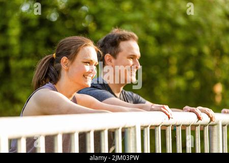 Giovane donna e uomo che fanno esercizi di stretching in natura Foto Stock