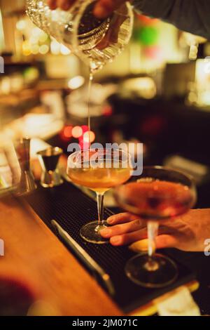 Uno shot verticale di un bicchiere riempito con una bevanda alcolica nel pub Foto Stock