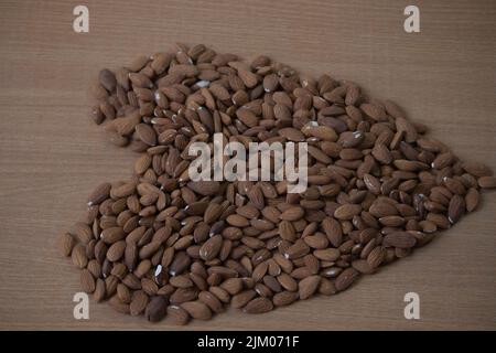 Concetto di pile di mandorle a forma di cuore. Nuts.Almonds freschi in forma di Hart. Foto Stock