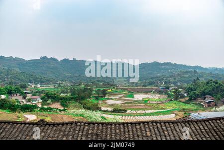 Una bella vista di un vasto paesaggio agricolo con montagne verdi sullo sfondo Foto Stock