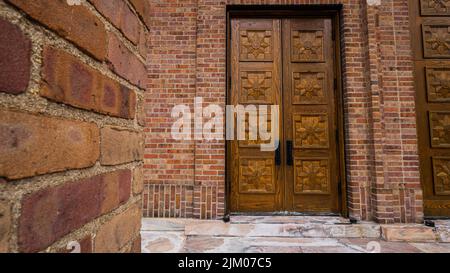 Una bella foto di porte di legno su una chiesa di pietra ad Asheville, North Carolina Foto Stock