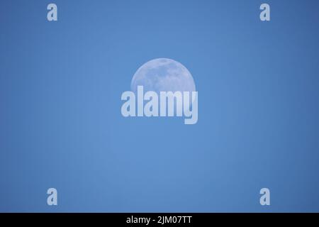 Un primo piano sereno vista della luna contro un cielo blu Foto Stock