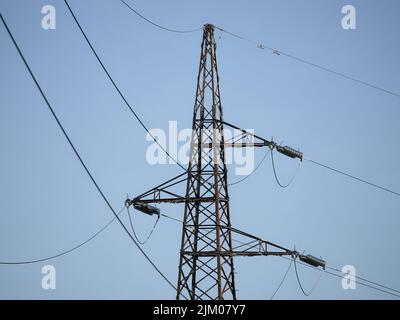 A closeup of a dead-end tower or anchor pylon against the blue sky. Foto Stock
