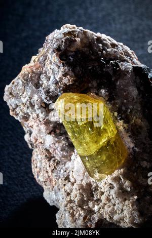 Un primo piano verticale di una rara fila minerale cristallo giallo non tagliato Foto Stock