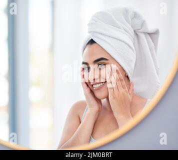 La mia dermatologa sarà così soddisfatta dei miei progressi. Giovane donna che si diletta nello specchio del suo bagno. Foto Stock