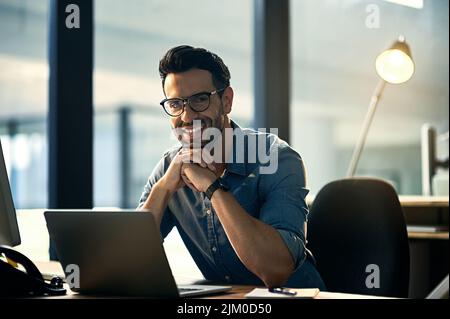 Niente mi dissuade dal mio sogno. Ritratto di un giovane uomo d'affari che utilizza un computer portatile durante una notte tarda al lavoro. Foto Stock