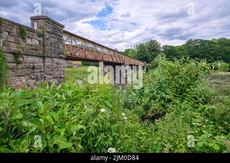 Un vecchio ponte in acciaio, arrugginito, ferroviario, trenino, ora utilizzato come sentiero natura a piedi sul fiume Wye. A Tintern Abby vicino a Chepstow, Galles, United King Foto Stock