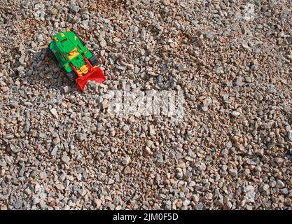 Trattori giocattolo su un mucchio di macerie, gioco per bambini Foto Stock