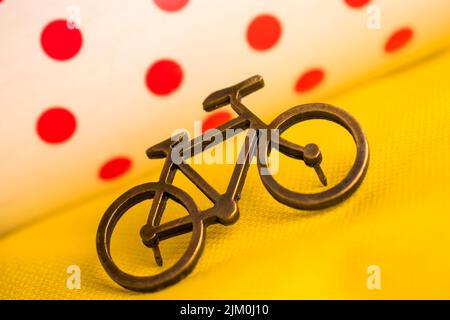 Un piccolo spilla per bicicletta su una t-shirt gialla per un tour della Francia con sfondo sfocato Foto Stock