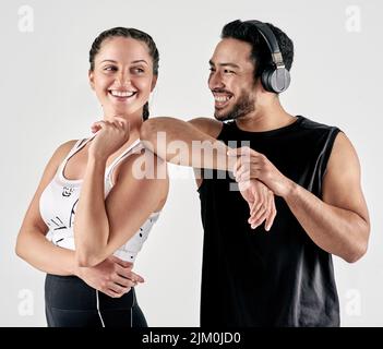 Devo amare la sensazione di diventare più forte. Studio girato di un giovane sportivo uomo e donna che si posano insieme su uno sfondo bianco. Foto Stock